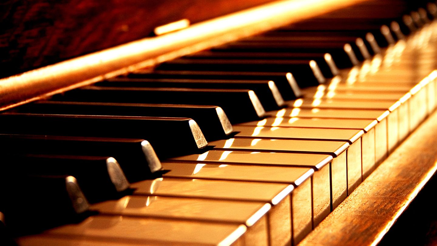 clavier de piano droit sous une lumiere jaune sombre